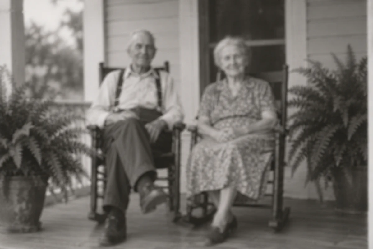 A black-and-white photograph of an older couple on a porch, before editing